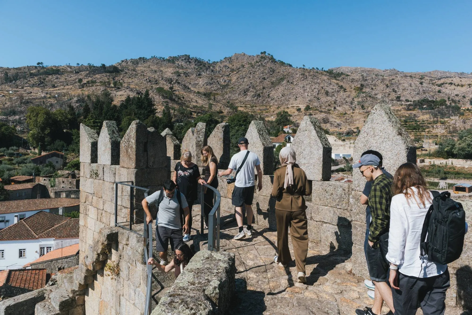 The group on the stone battlements of the castle in Castelo Novo, with a rocky hillside behind.